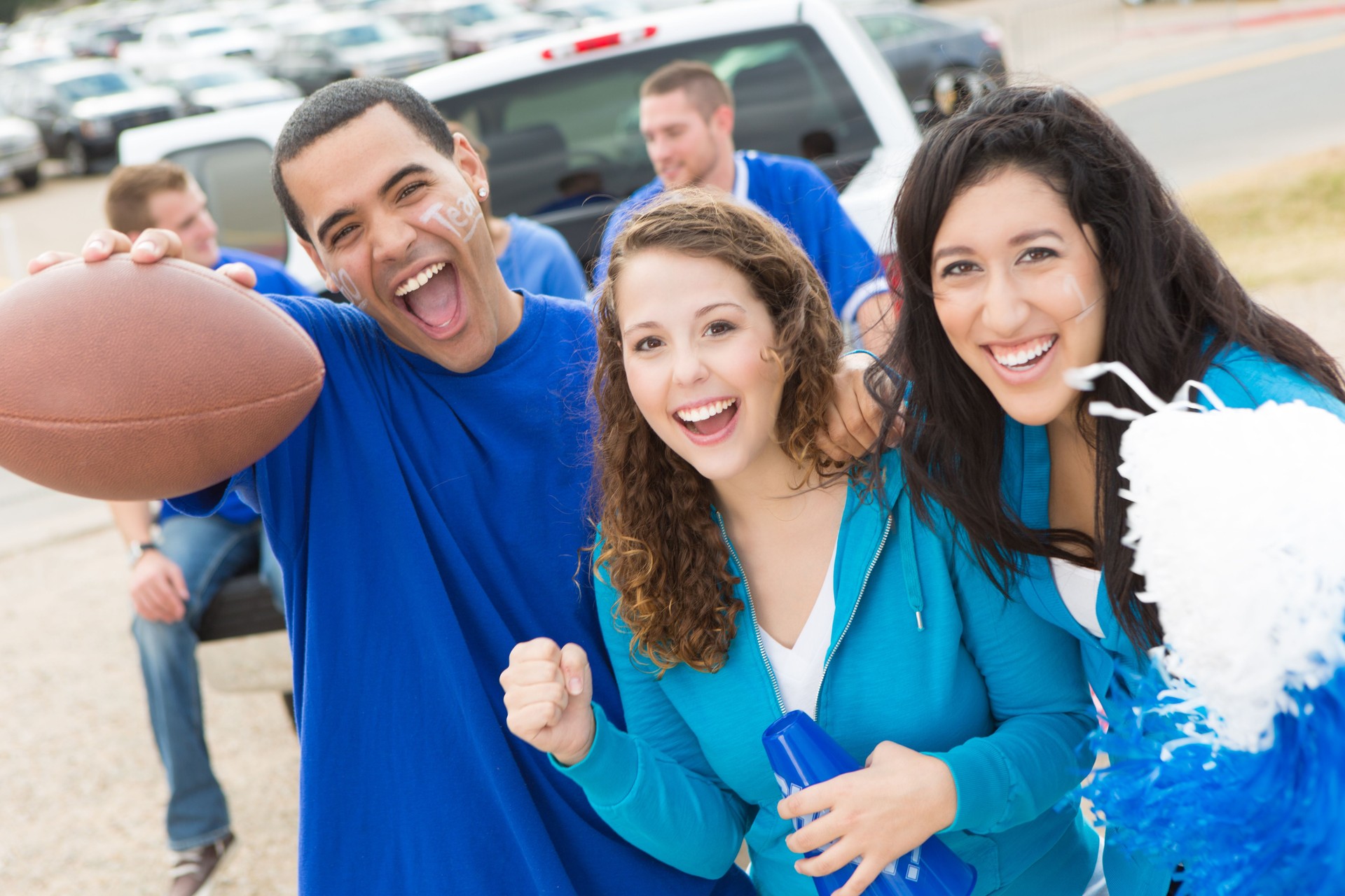 Cheering football fans at a stadium tailgate party